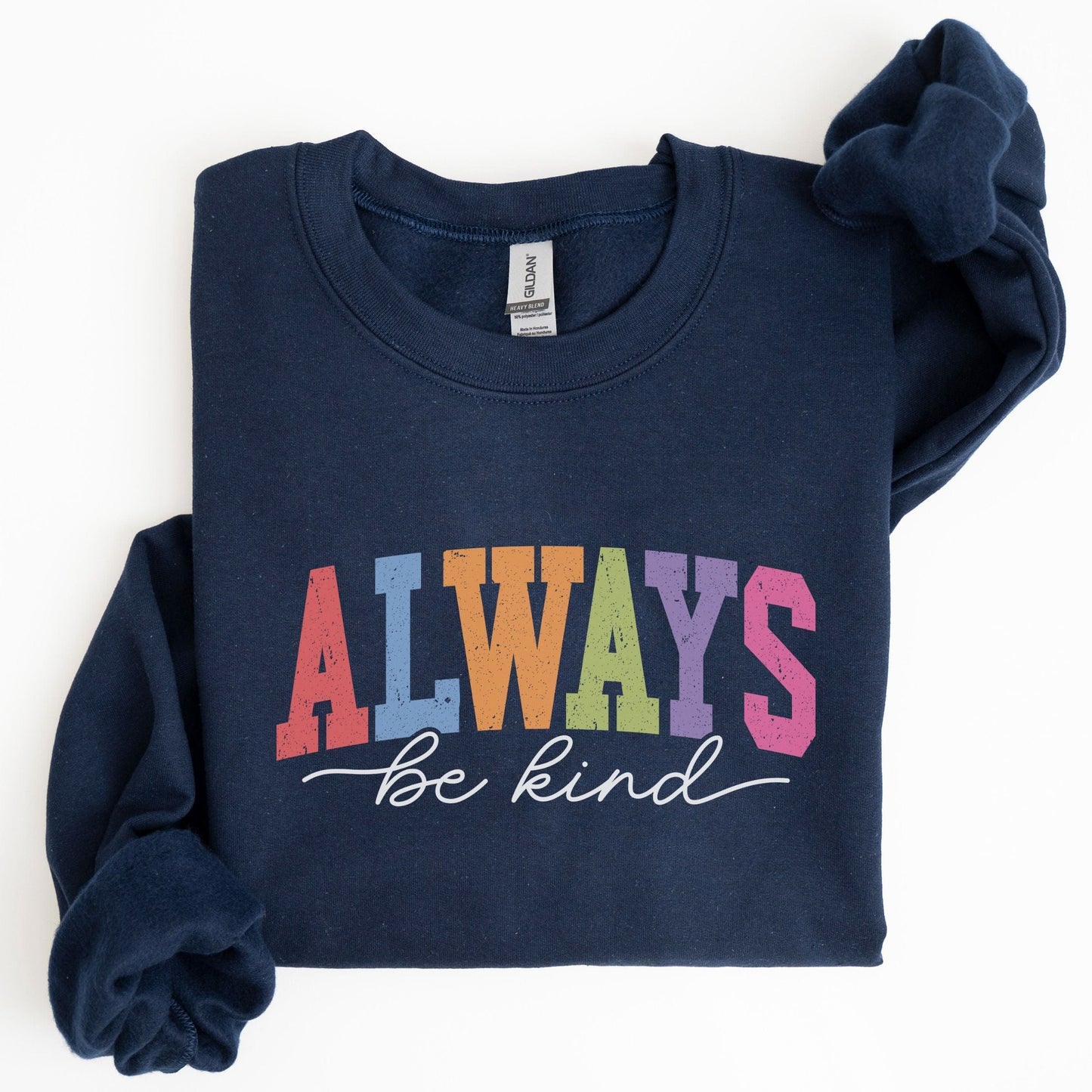 Retro rainbow “Always Be Kind” sweatshirt design with bold varsity letters in pastel colors and script font underneath on a cozy fleece pullover.