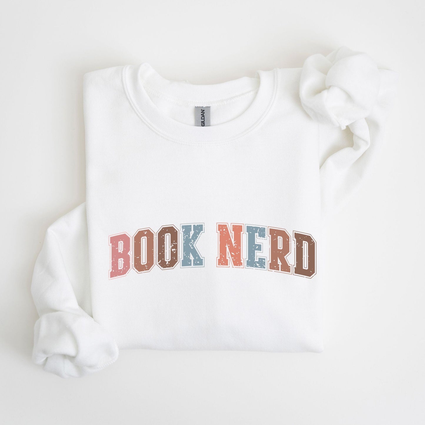 “Book Nerd” sweatshirt with retro textured lettering in muted tones — cozy crewneck for book lovers and casual vintage style.