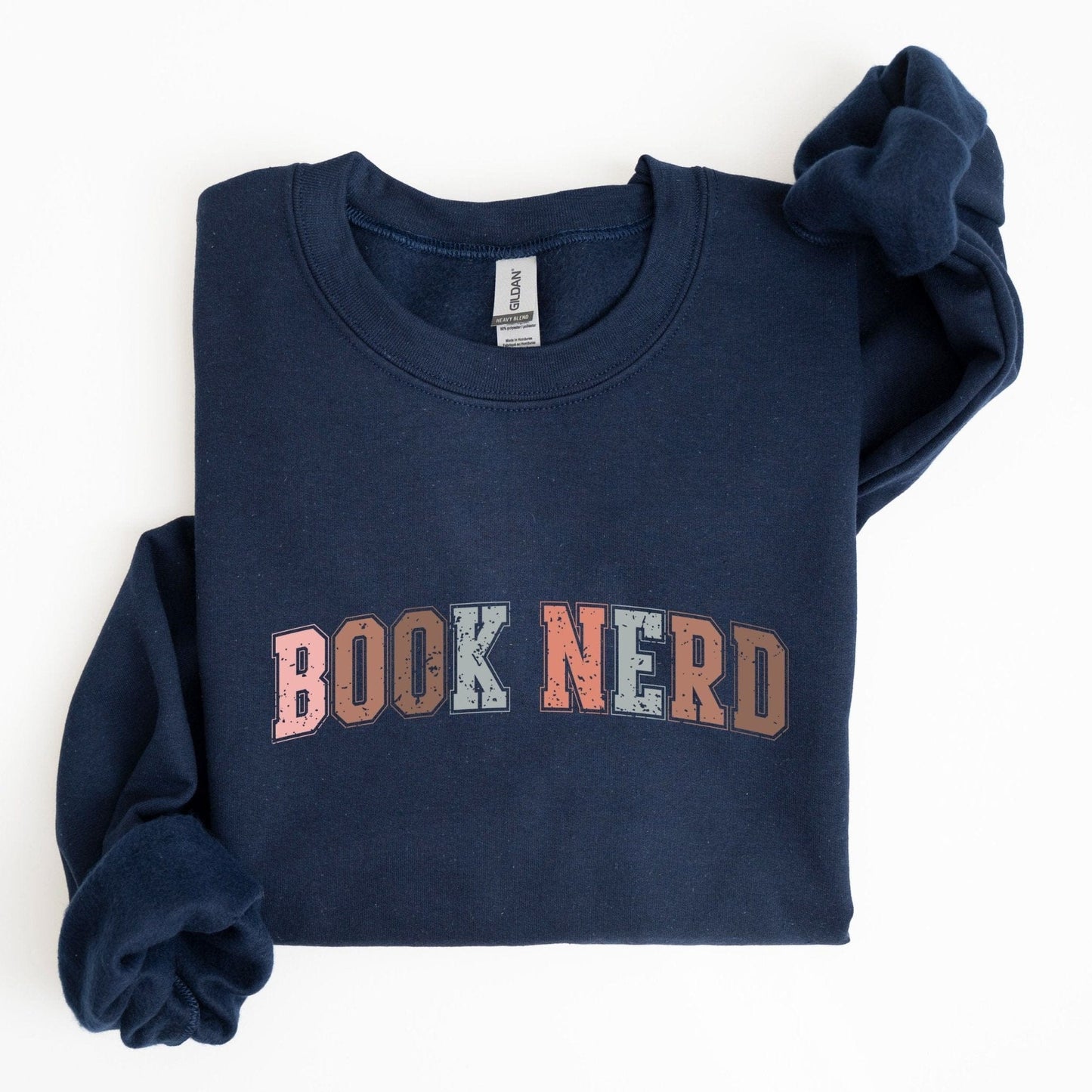 “Book Nerd” sweatshirt with retro textured lettering in muted tones — cozy crewneck for book lovers and casual vintage style.