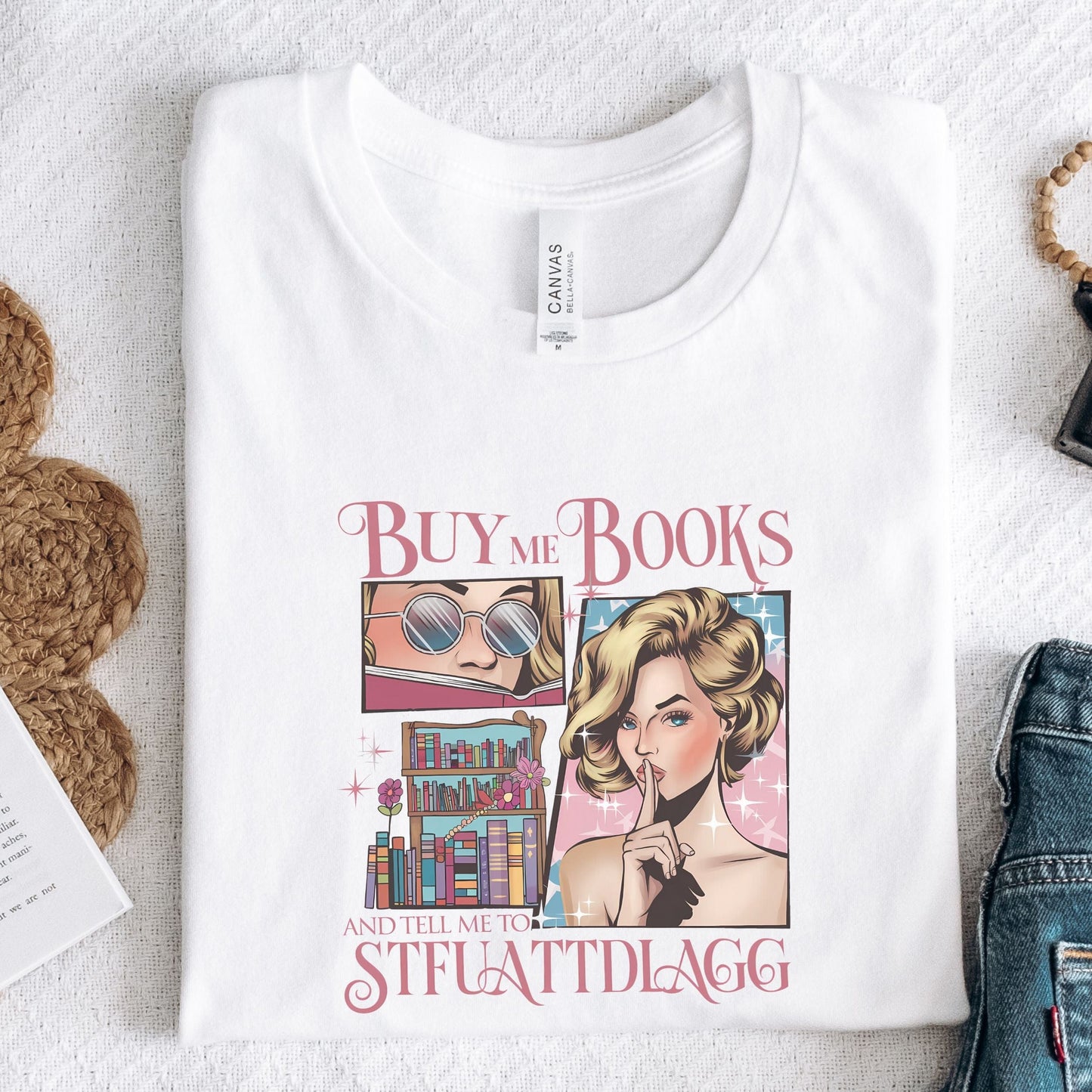 “Buy Me Books and Tell Me to STFUATTDLAGG” t-shirt with retro glam comic art, sassy woman, bookshelves, and pink sparkly accents.