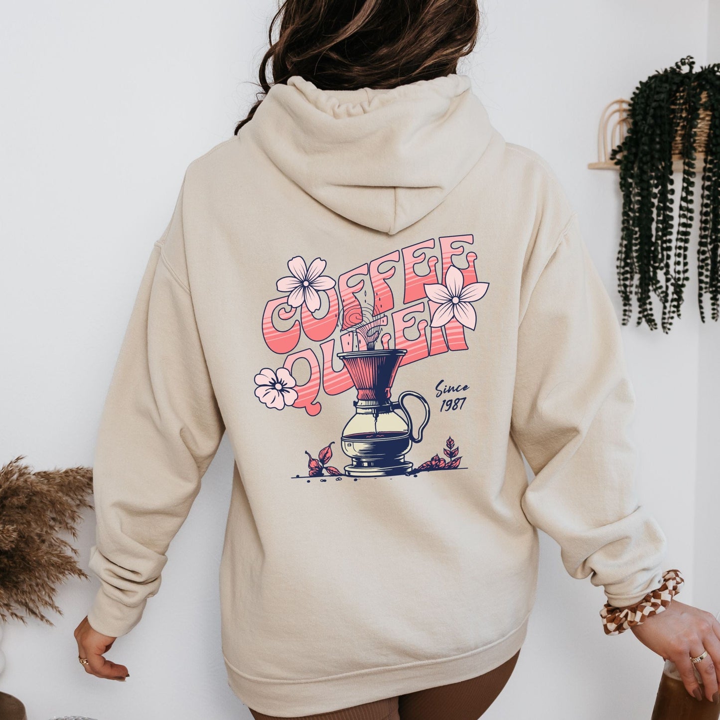 Retro-style “Coffee Queen” text with floral accents and a coffee pour-over illustration on back of a hoodie