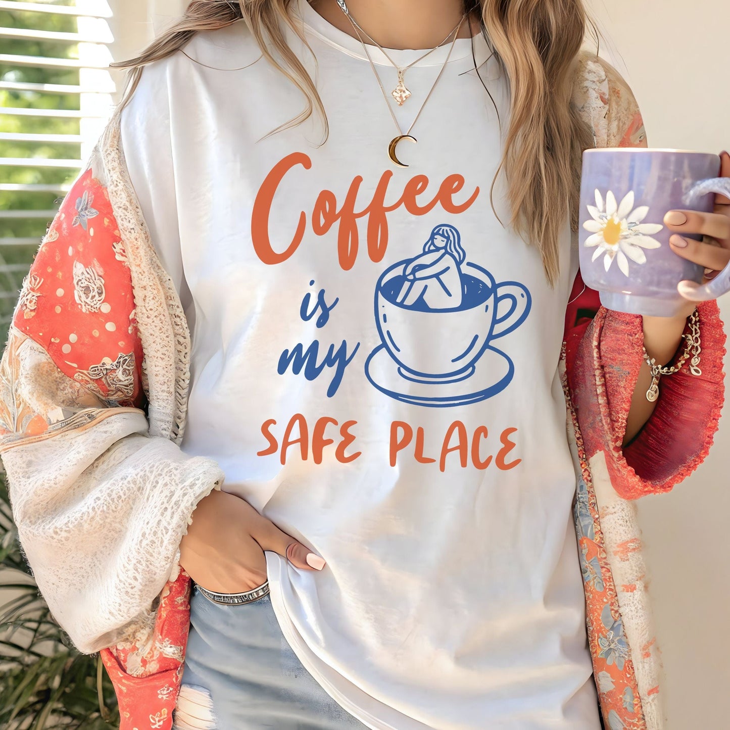 Blue and orange graphic t-shirt with text “Coffee is my safe place” featuring a girl sitting inside a coffee cup illustration.