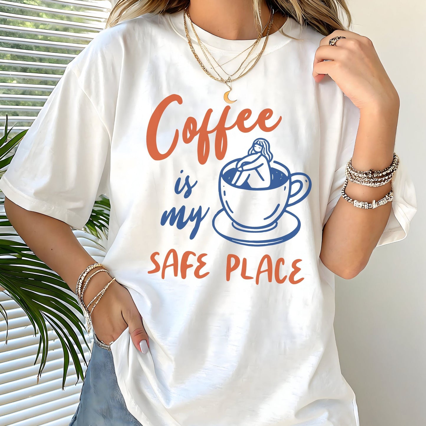 Blue and orange graphic t-shirt with text “Coffee is my safe place” featuring a girl sitting inside a coffee cup illustration.