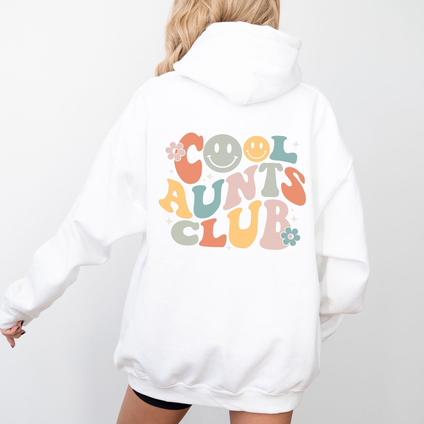 Retro multicolor “Cool Aunts Club” graphic with smiley faces and flowers on the back of a hoodie