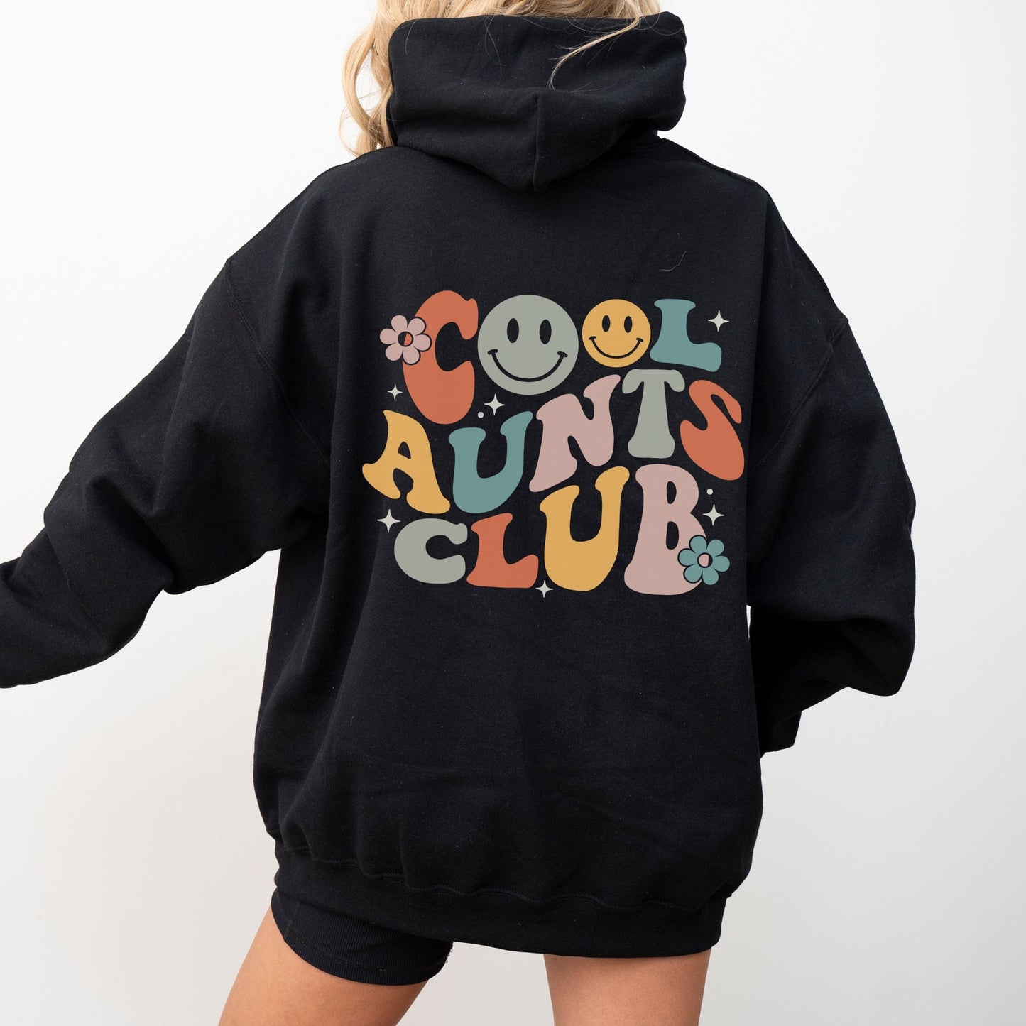Retro multicolor “Cool Aunts Club” graphic with smiley faces and flowers on the back of a hoodie