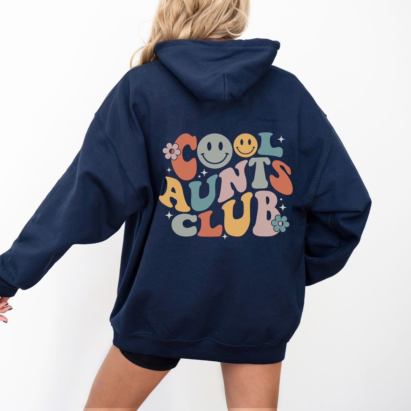 Retro multicolor “Cool Aunts Club” graphic with smiley faces and flowers on the back of a hoodie