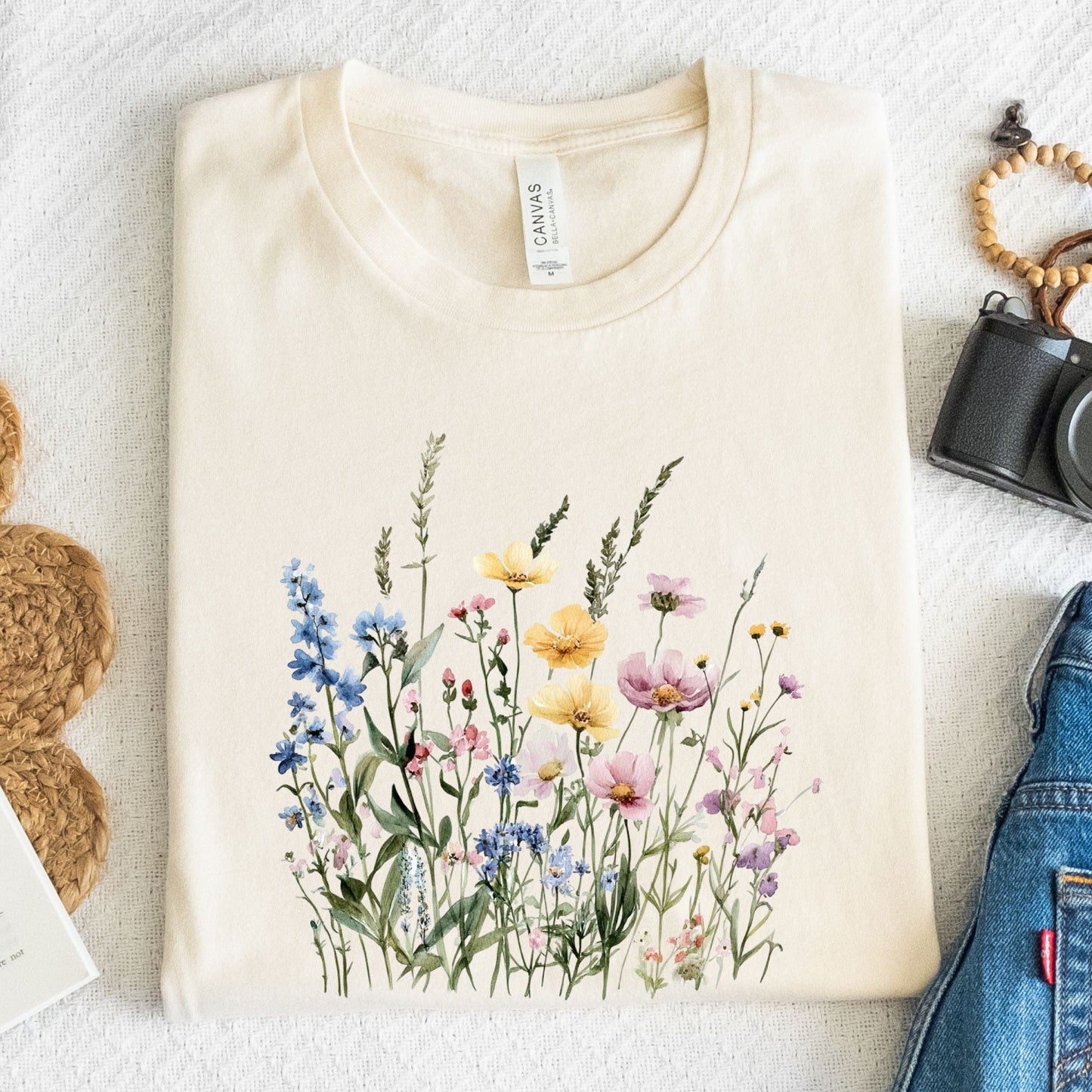 Watercolor wildflower illustration on a cottagecore-style t-shirt in natural