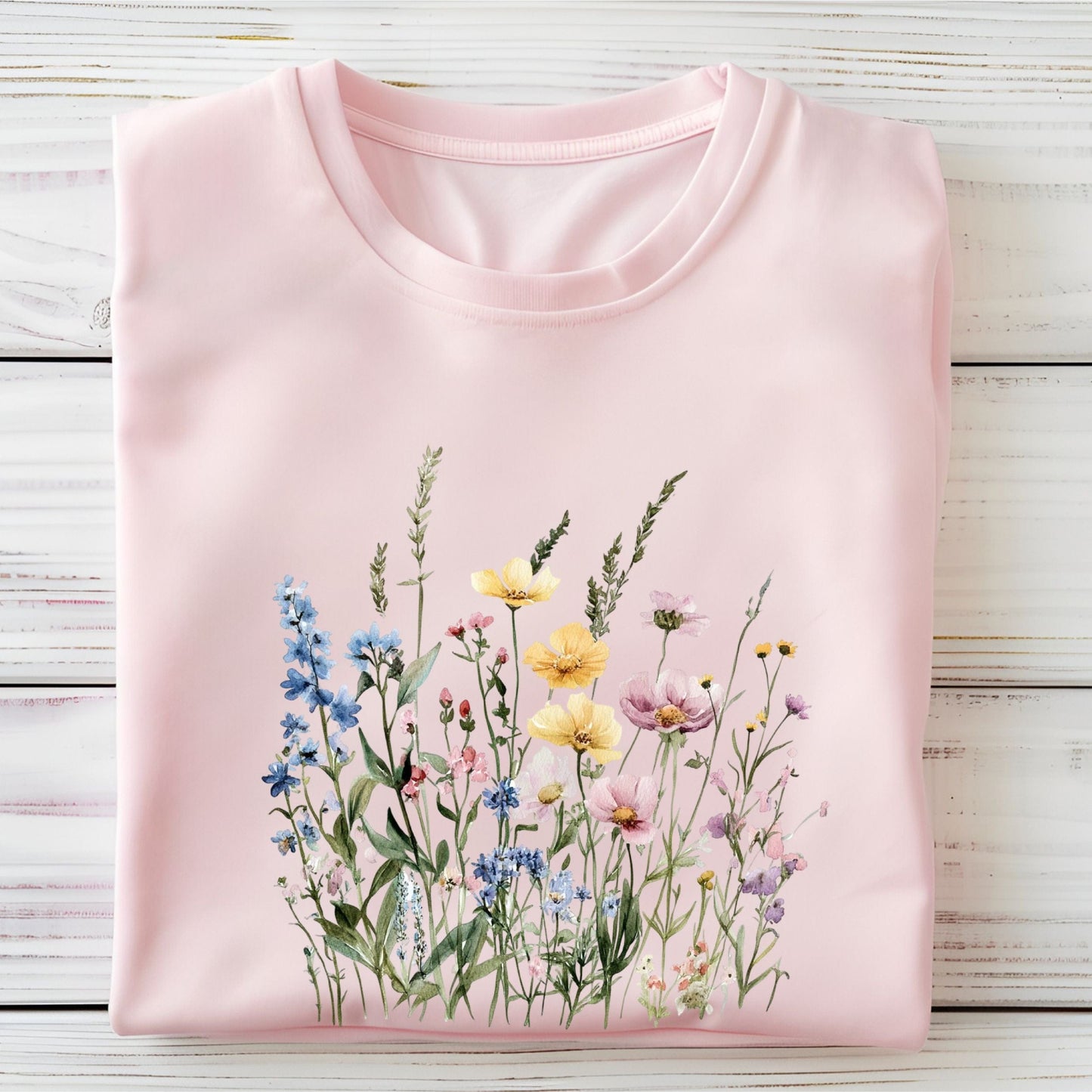 Watercolor wildflower illustration on a cottagecore-style t-shirt in soft pink