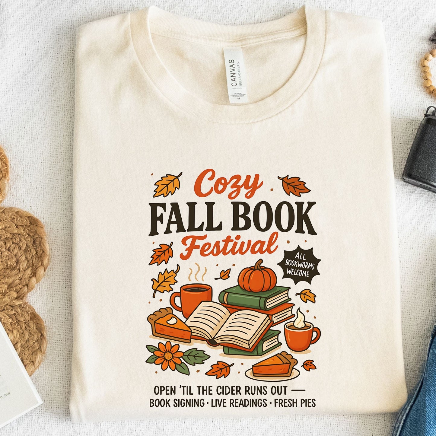 Cozy Fall Book Festival t-shirt with books, pumpkin pie, cider mugs, and autumn leaves in retro fall colors.