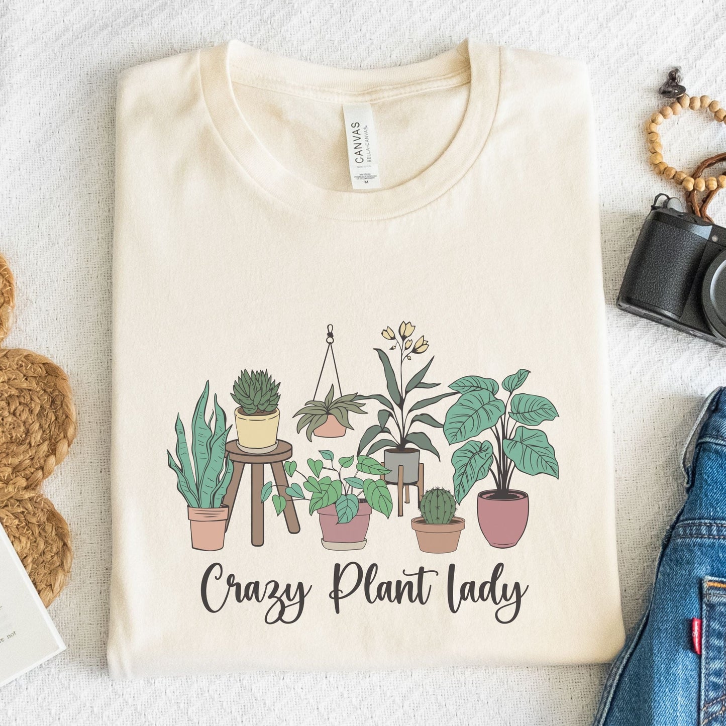“Crazy Plant Lady” t-shirt with hand-drawn houseplants in terra cotta pots, stands, and hanging planters. Earthy, whimsical design.
