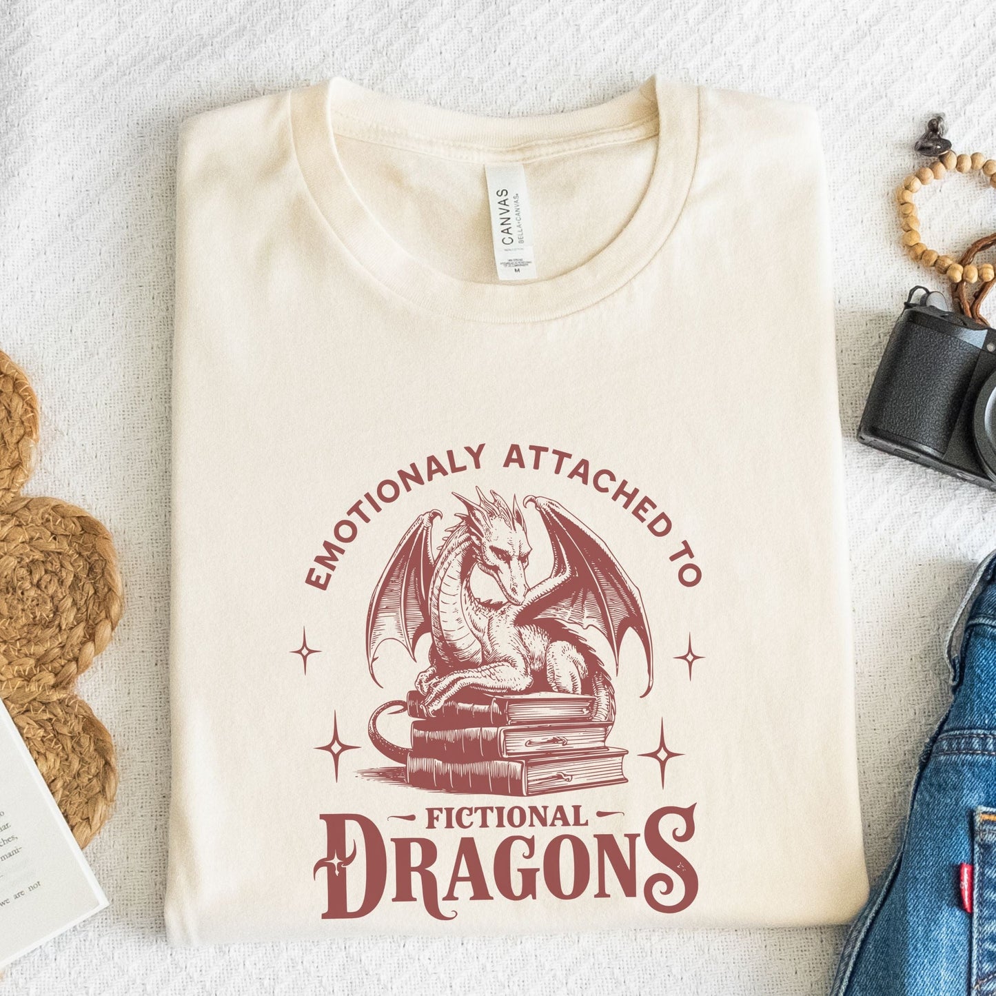 Folded t-shirt with vintage-style dragon illustration in natural