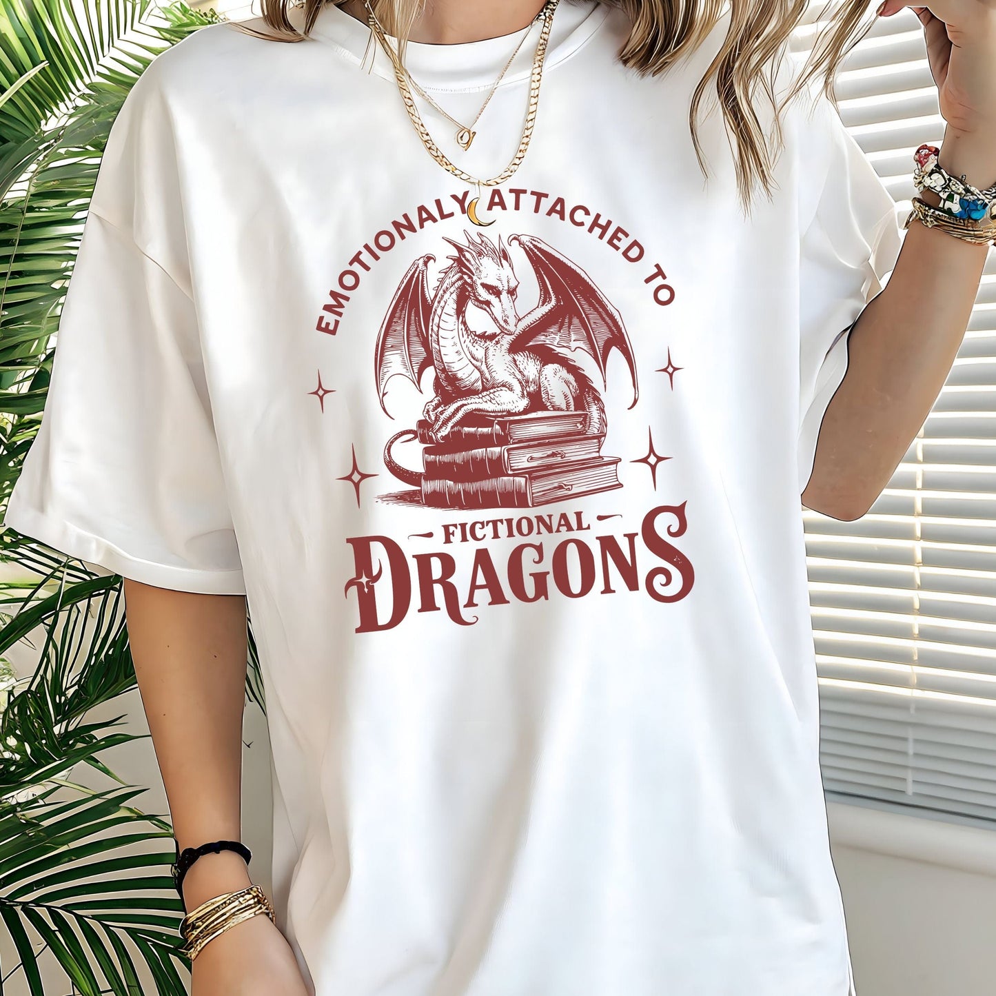 Person wearing “Emotionally Attached to Fictional Dragons” t-shirt with dragon + book stack design