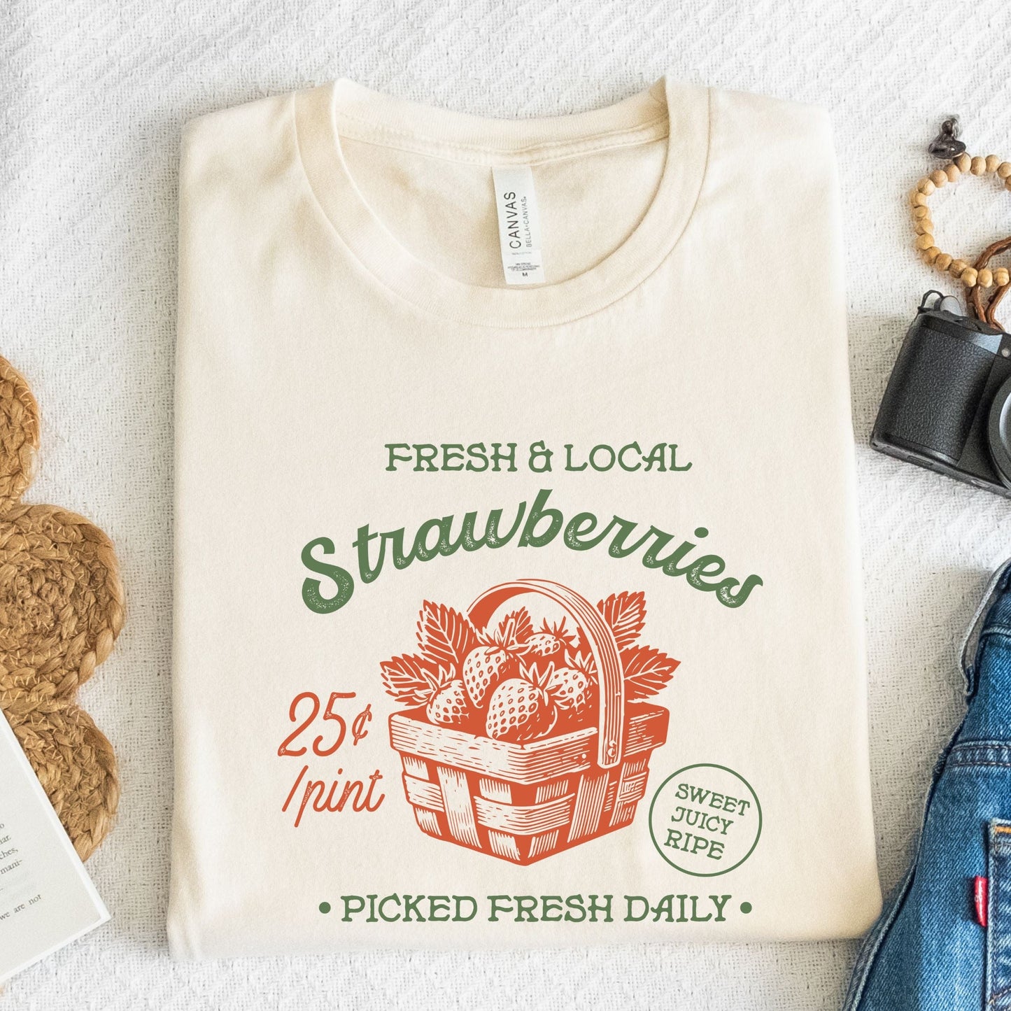 Folded tee with vintage strawberry print and retro produce design in natural