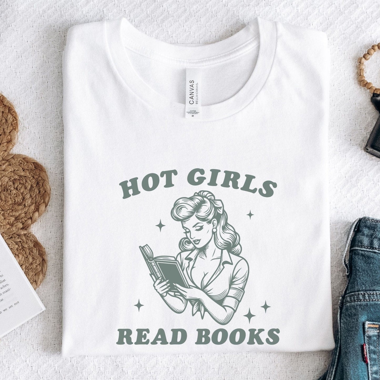 “Hot Girls Read Books” t-shirt with retro-style pin-up woman reading a book in vintage line art, surrounded by stars.