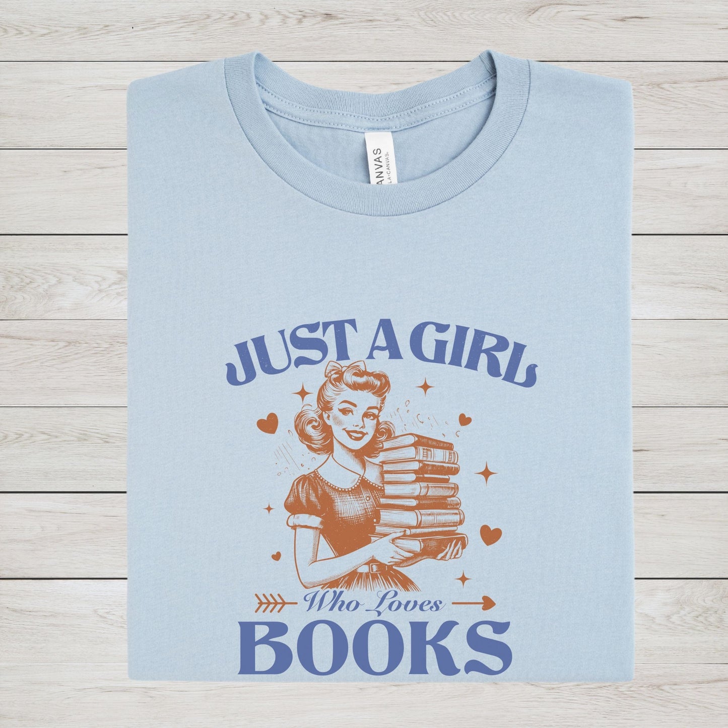 Vintage-style graphic tee that says "Just a Girl Who Loves Books" with a retro girl holding a stack of books and heart accents.