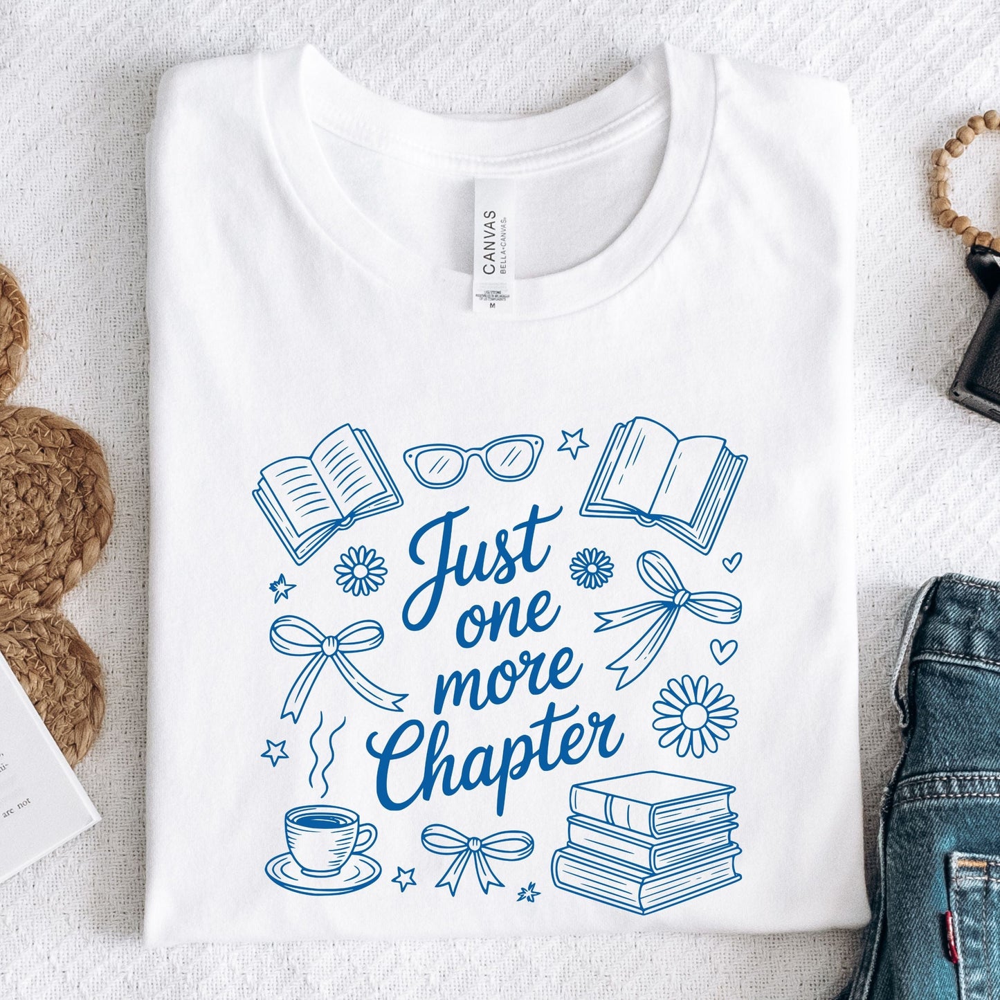 Just One More Chapter t-shirt in a cozy book lover aesthetic with bows, books, and daisies on front design