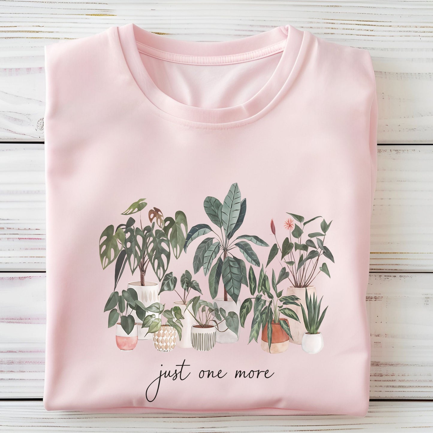 T-shirt with potted houseplants in watercolor style — monstera, rubber plant, snake plant, and more on a black background.