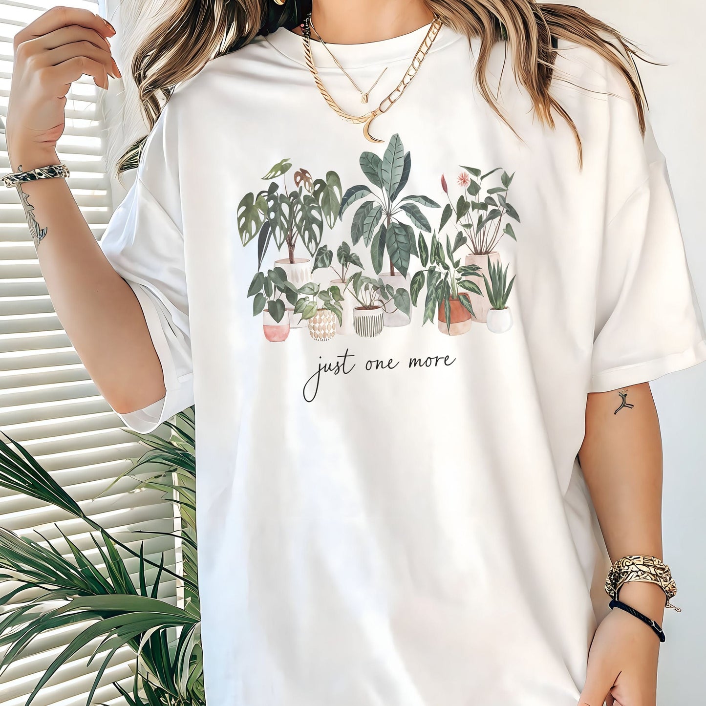 T-shirt with potted houseplants in watercolor style — monstera, rubber plant, snake plant, and more on a black background.