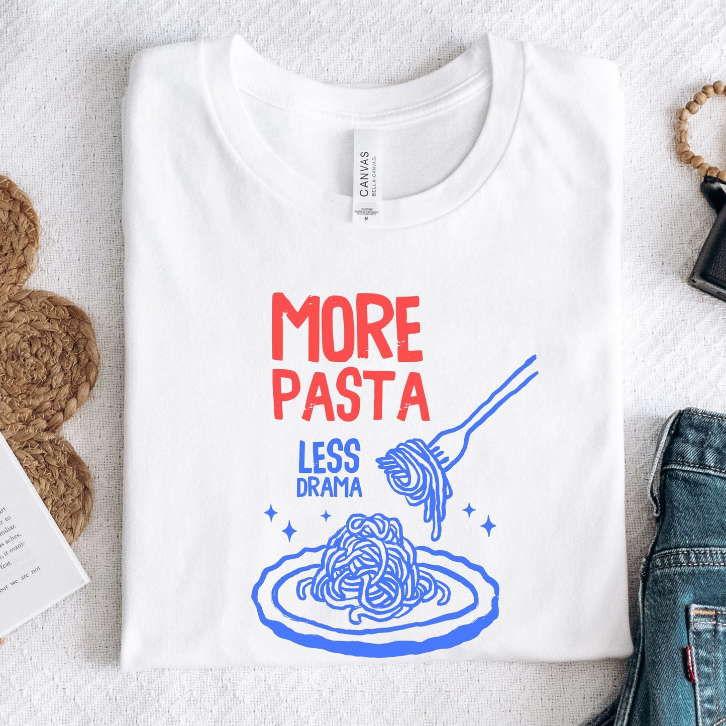 T-shirt with a plate of spaghetti and fork illustration and “More Pasta, Less Drama” text in white