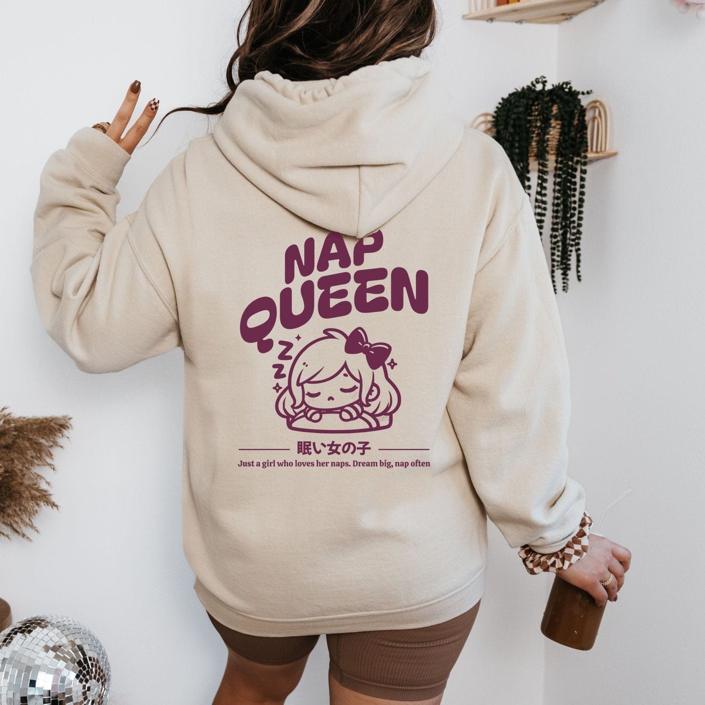 Hoodie with back print featuring "Nap Queen" text, a sleepy girl with bow, Zzz symbols, and kawaii-inspired style — perfect for cozy nap lovers.
