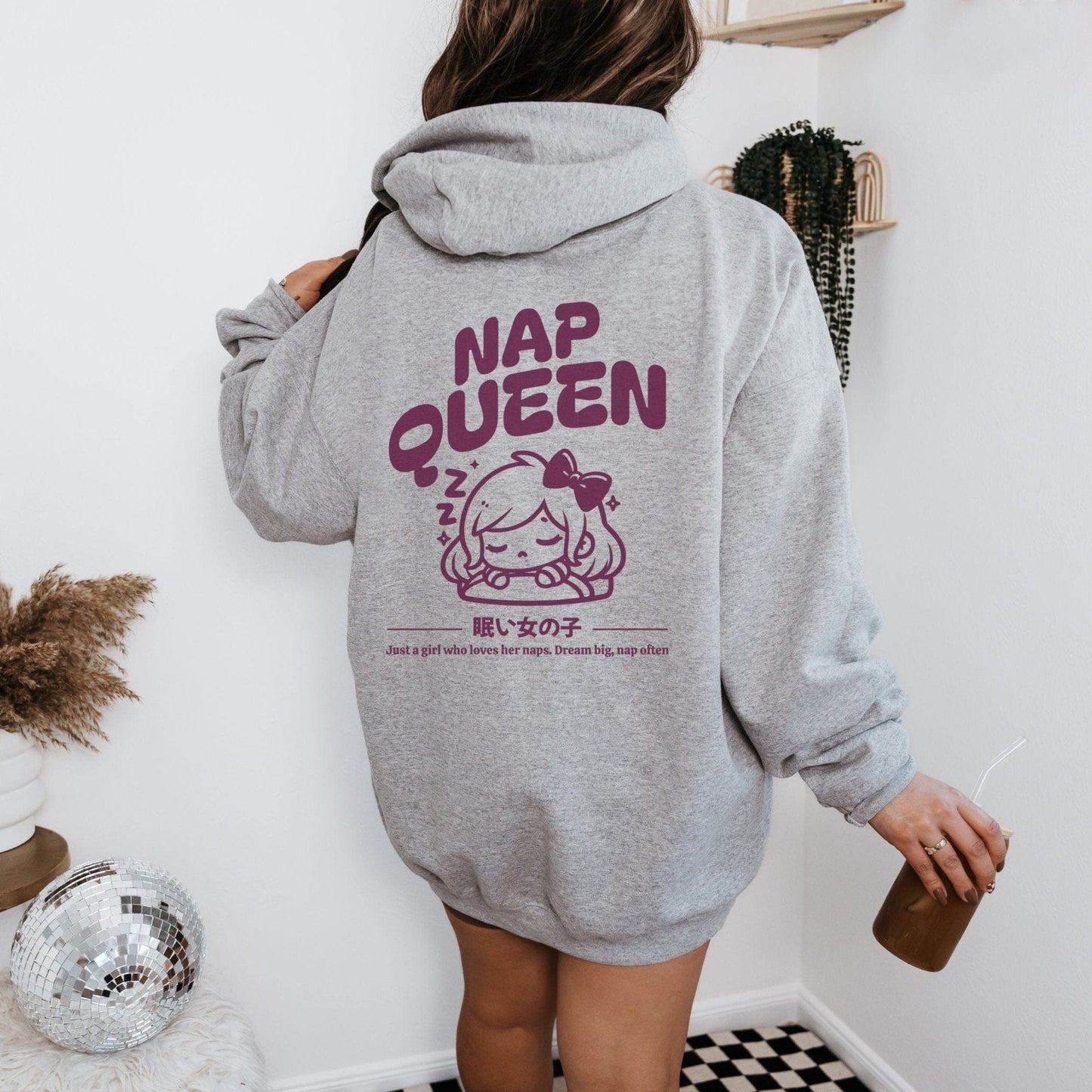 Hoodie with back print featuring "Nap Queen" text, a sleepy girl with bow, Zzz symbols, and kawaii-inspired style — perfect for cozy nap lovers.