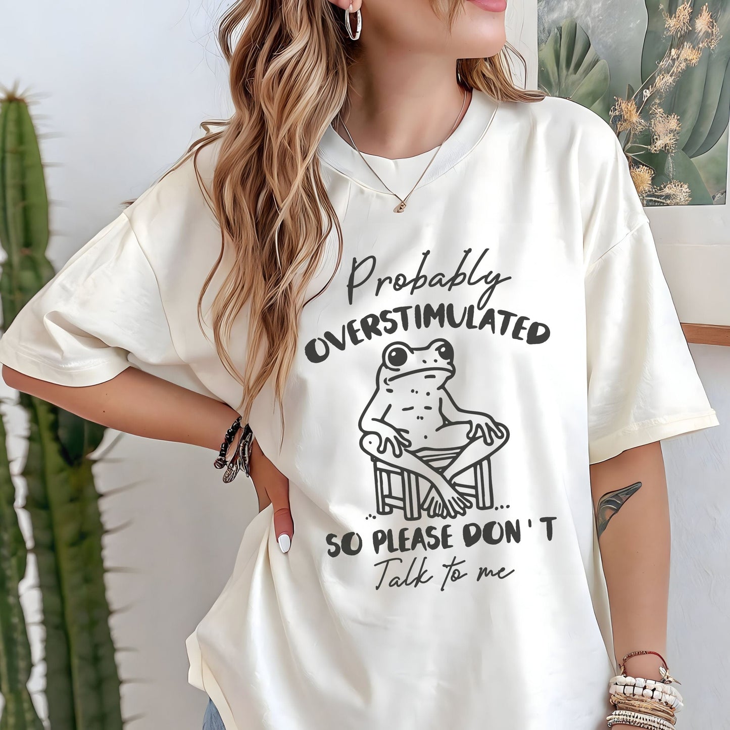 T-shirt with a cute frog illustration and "Probably Overstimulated" quote in hand-drawn font