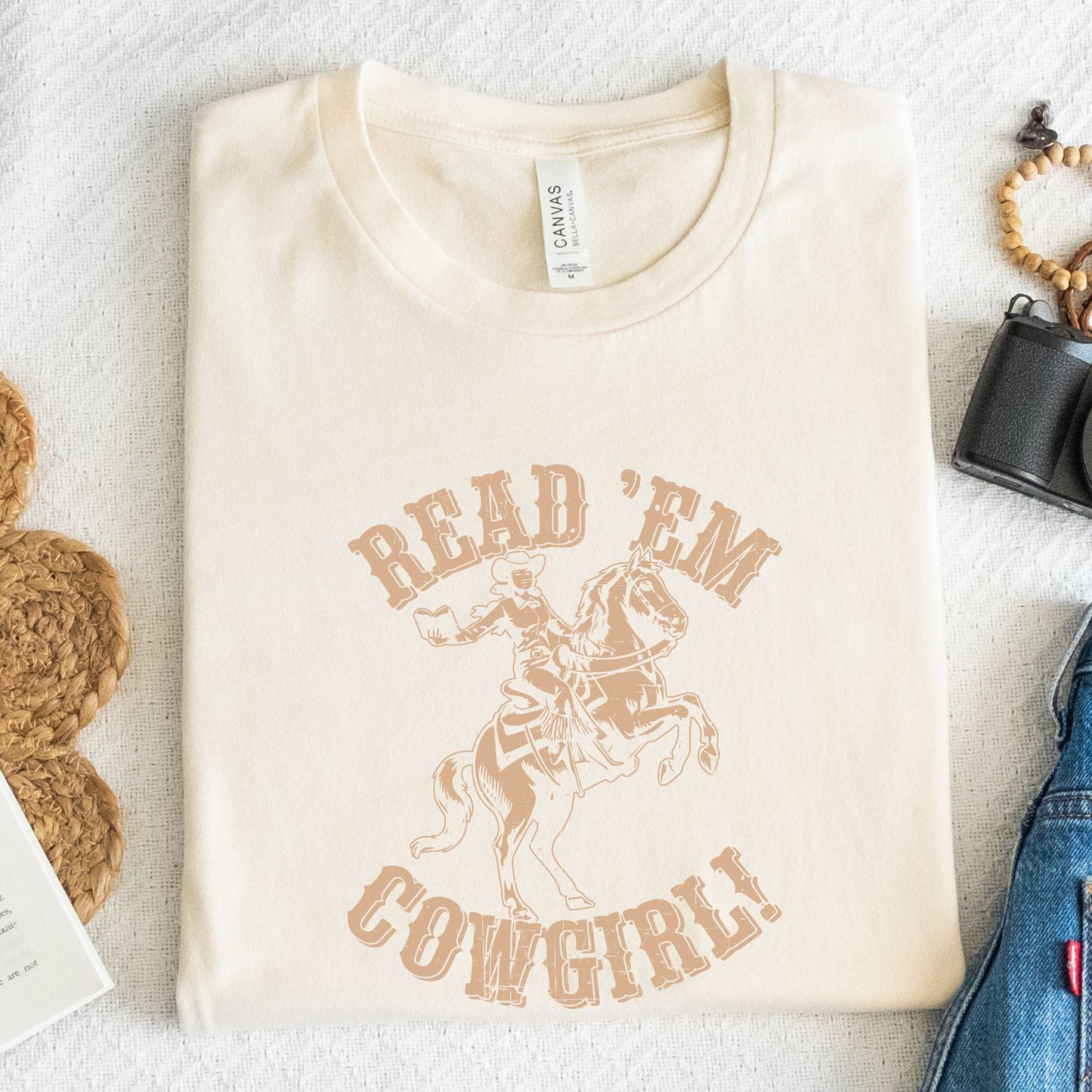 Folded tee with vintage cowgirl and horse illustration in natural