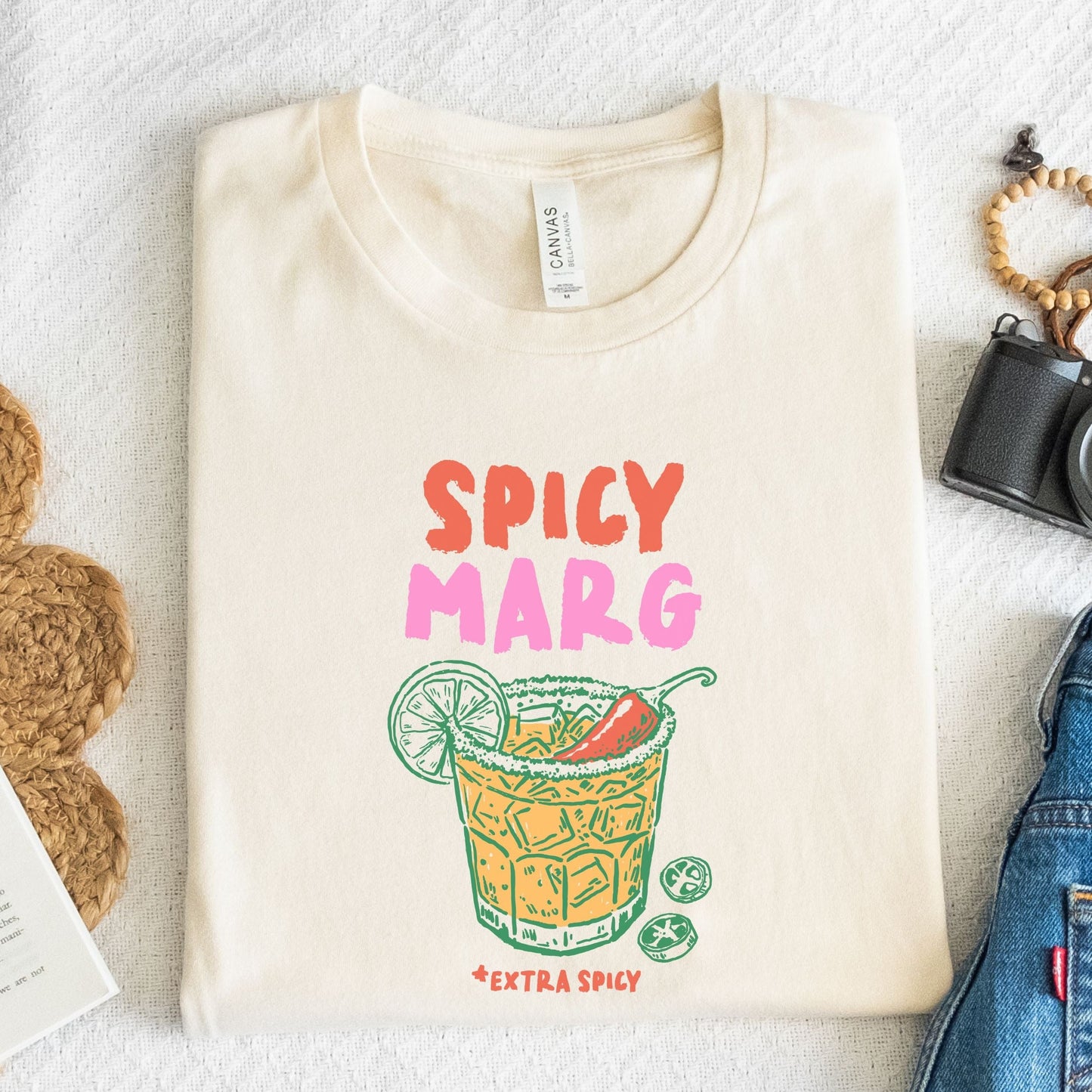 Hand-drawn spicy margarita graphic t-shirt with vibrant drink and lime illustration on soft cotton tee in natural