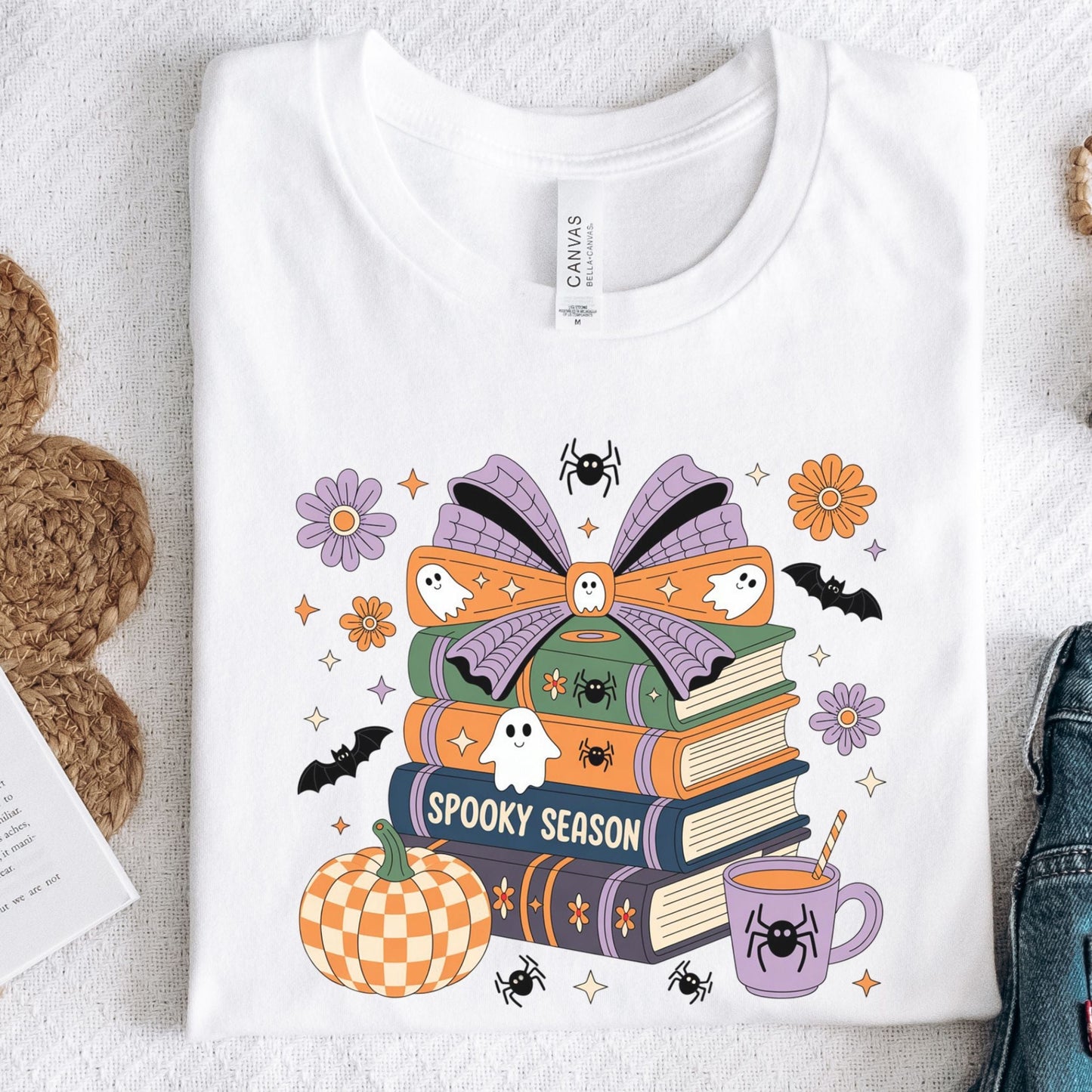 Halloween t-shirt with colorful stack of books, ghosts, pumpkin, and coffee cup reading “Spooky Season.”