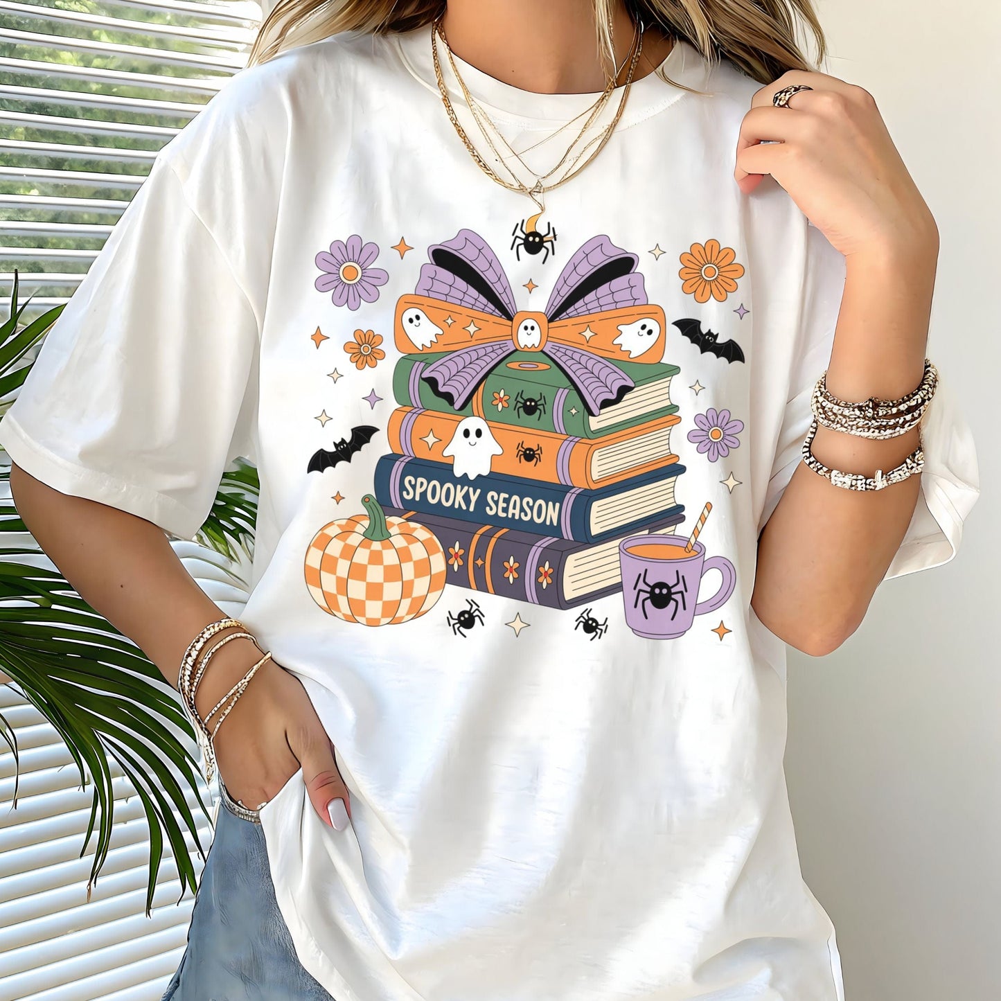 Halloween t-shirt with colorful stack of books, ghosts, pumpkin, and coffee cup reading “Spooky Season.”