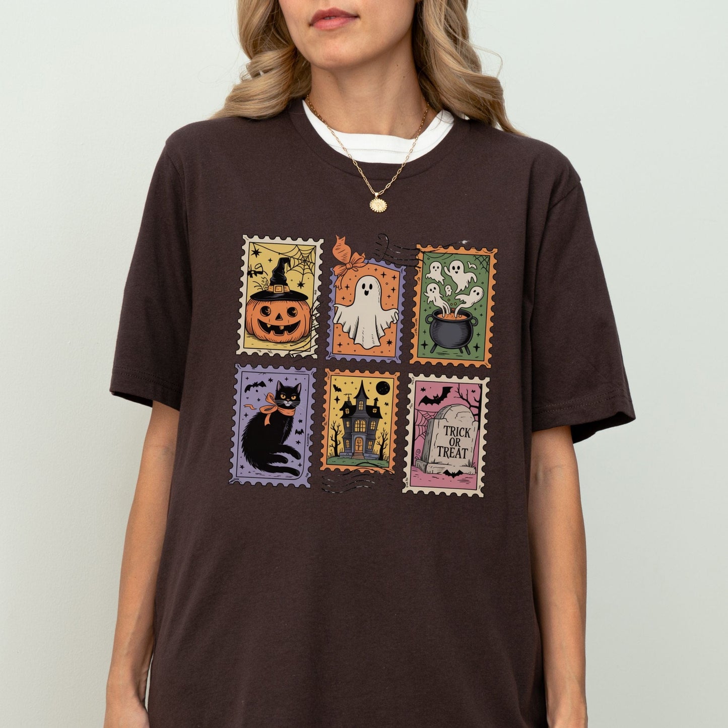 Vintage Halloween t-shirt with postage stamp illustrations of ghosts, pumpkins, black cat, haunted house, and trick-or-treat