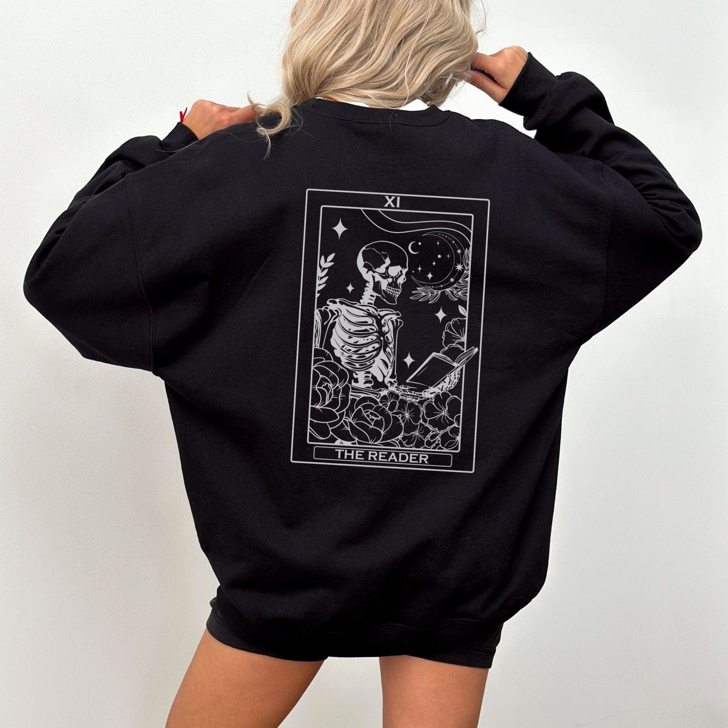 “The Reader Tarot” sweatshirt with mystical tarot card illustration printed on the back, perfect for book lovers and cozy fall vibes.