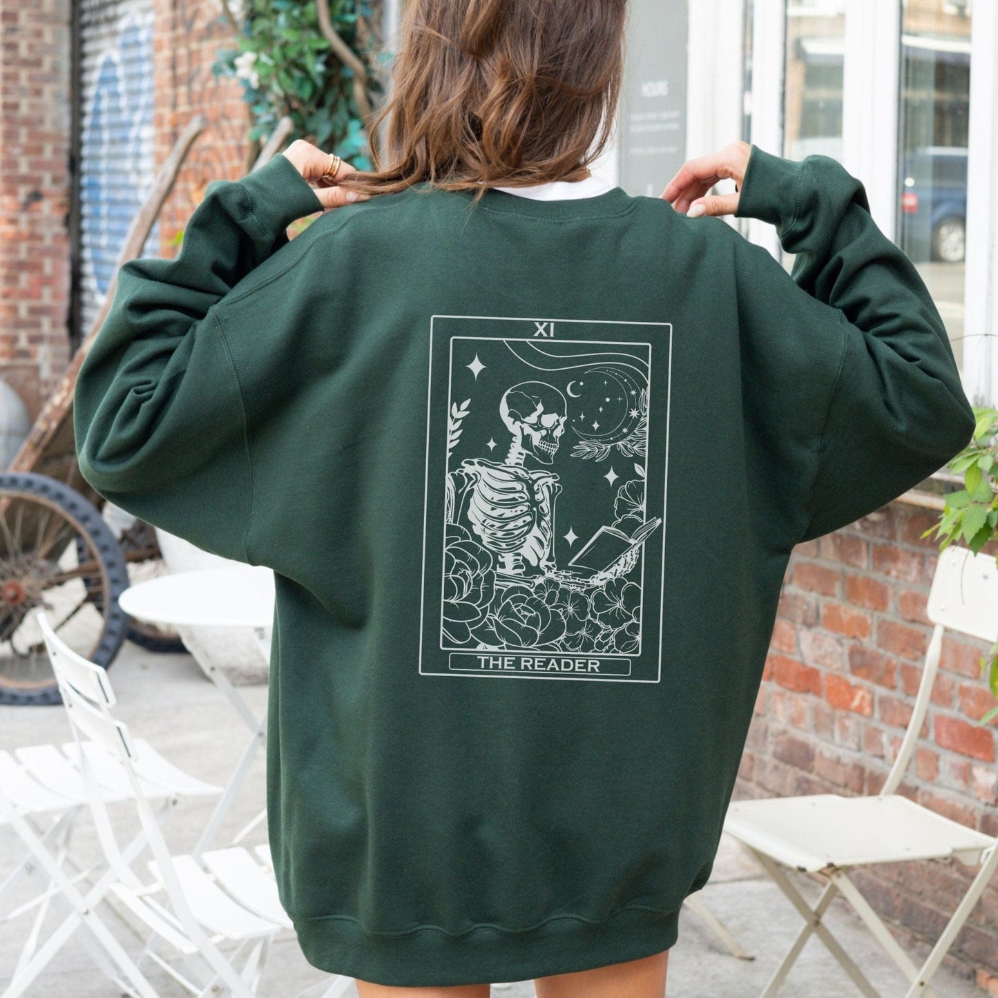 “The Reader Tarot” sweatshirt with mystical tarot card illustration printed on the back, perfect for book lovers and cozy fall vibes.