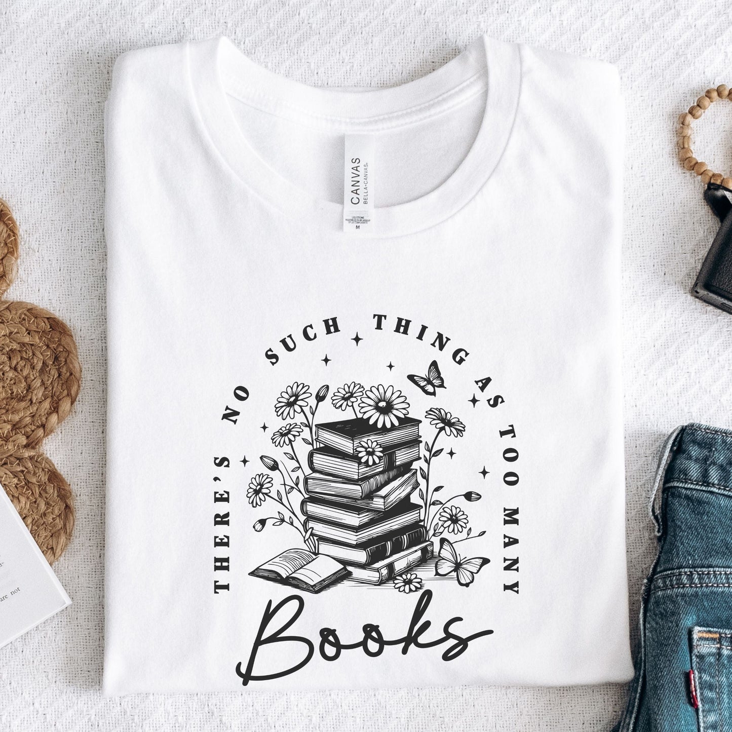“Too Many Books, Not Enough Time” t-shirt with minimalist stacked books and handwritten lettering in black line art style.