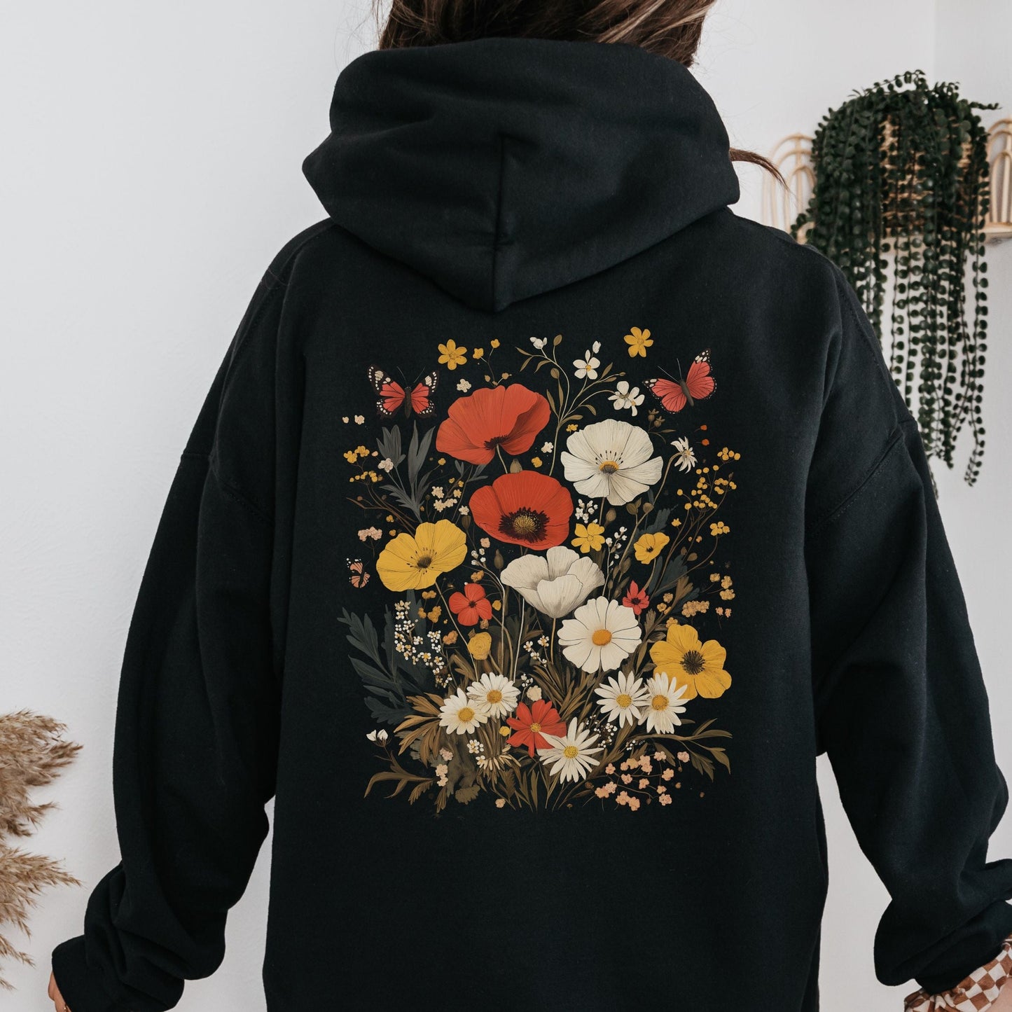 Back of hoodie with vintage wildflower bouquet and butterflies — cozy spring sweatshirt for floral lovers.