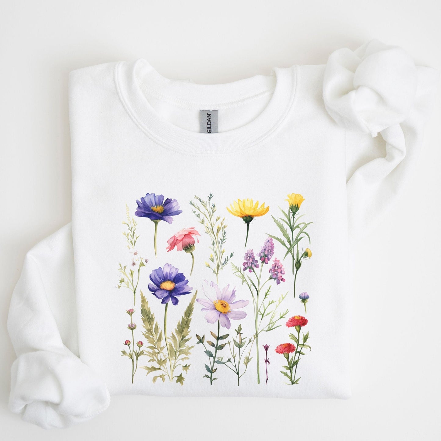 Vintage-style wildflower garden design on a cozy sweatshirt in soft spring tones in white