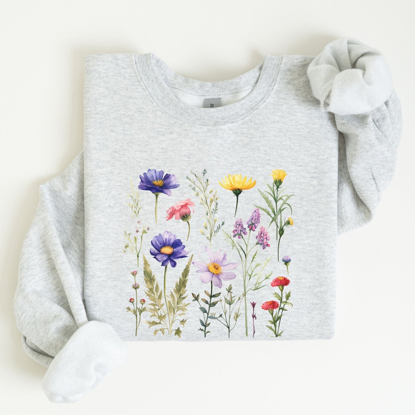Vintage-style wildflower garden design on a cozy sweatshirt in soft spring tones in ash