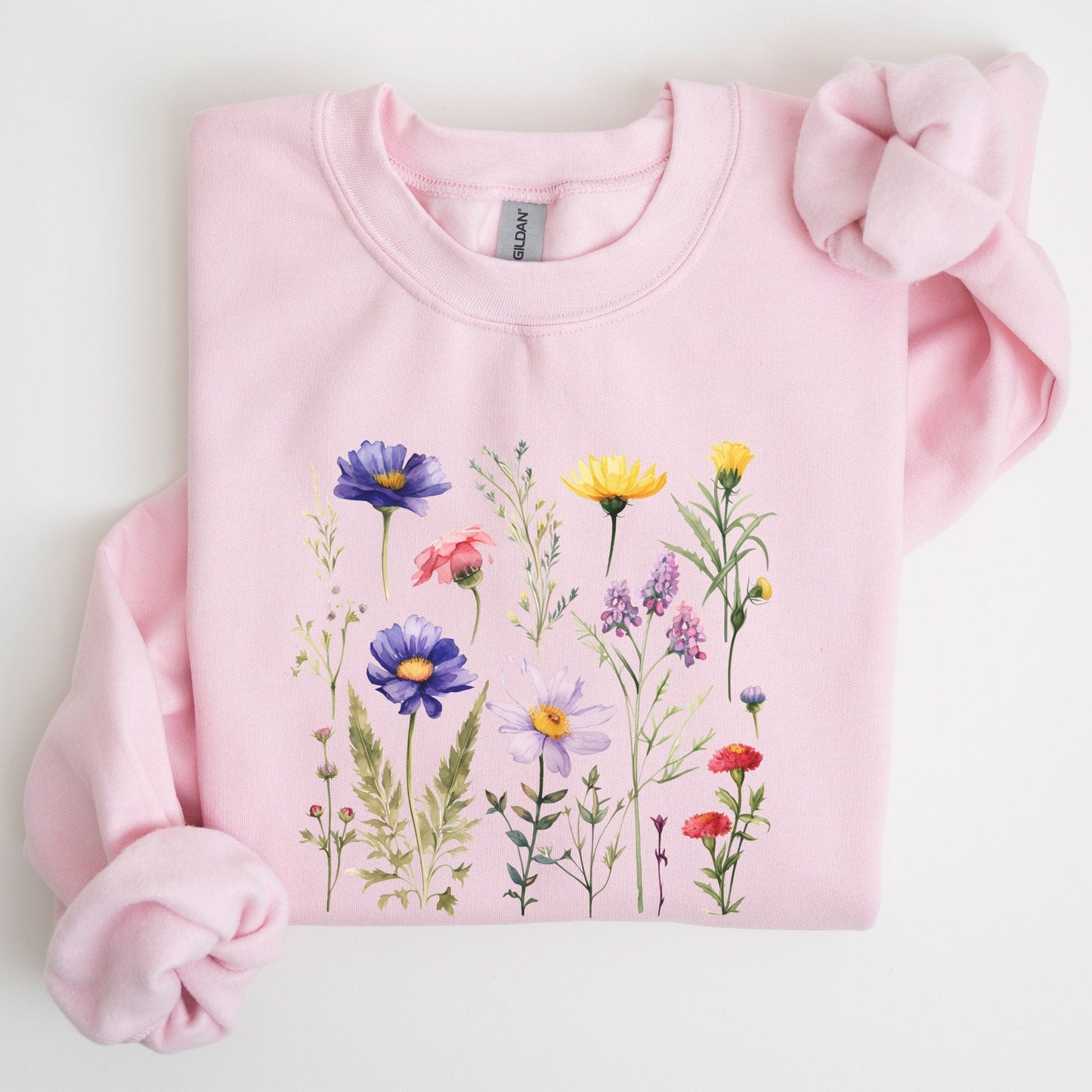 Vintage-style wildflower garden design on a cozy sweatshirt in soft spring tones in soft pink