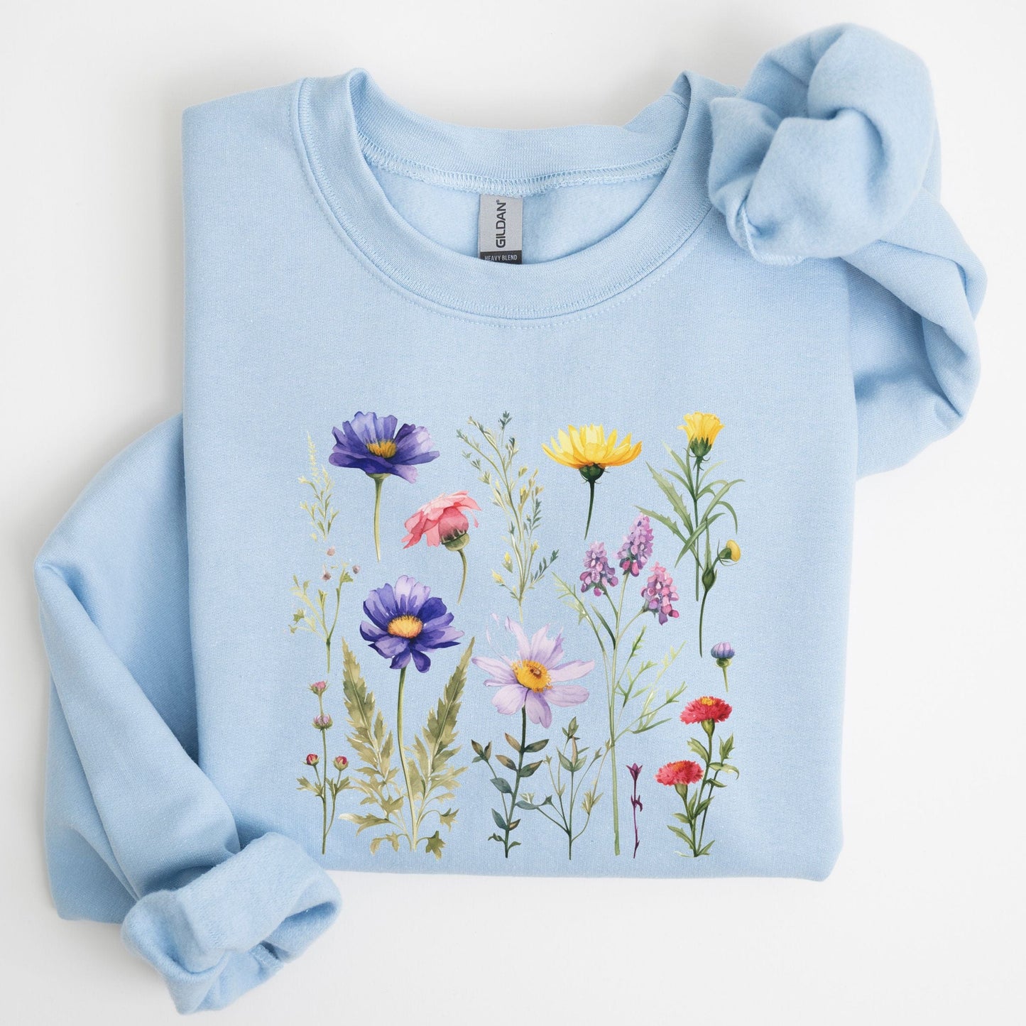 Vintage-style wildflower garden design on a cozy sweatshirt in soft spring tones in light blue