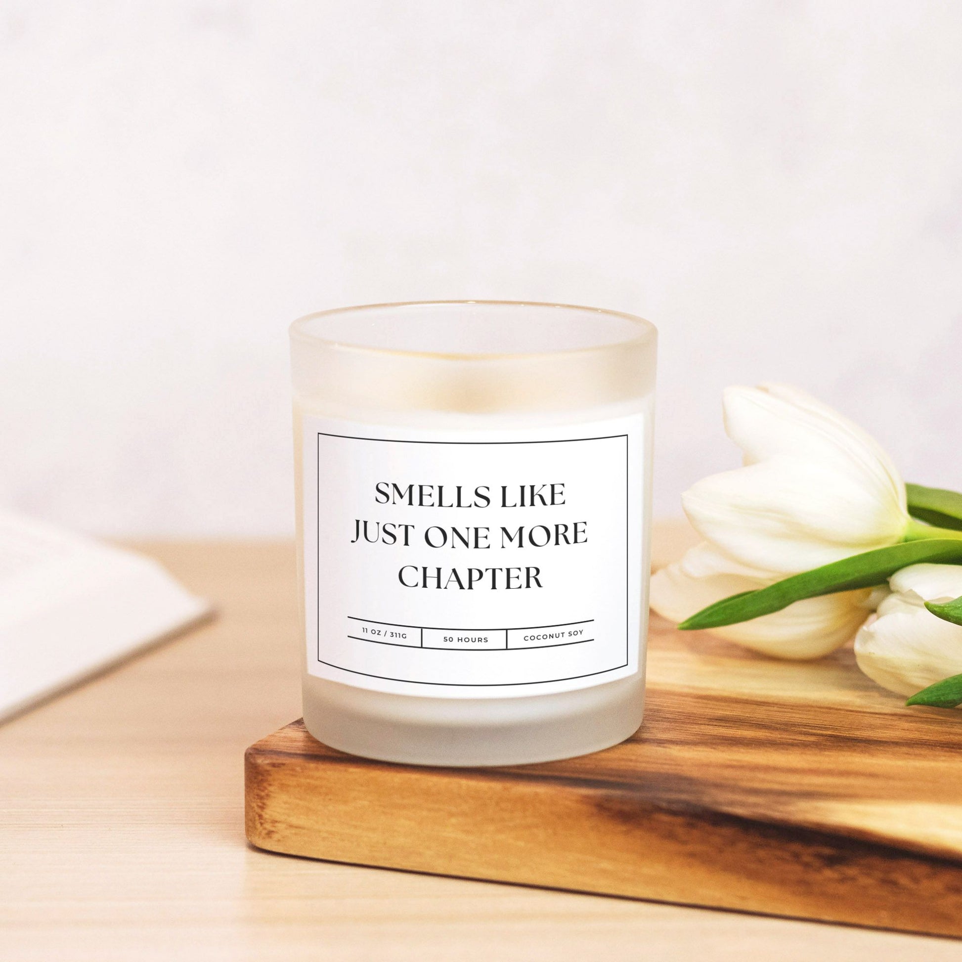 11 oz frosted glass candle with "Smells Like Just One More Chapter" design, perfect for book lovers and cozy nights.