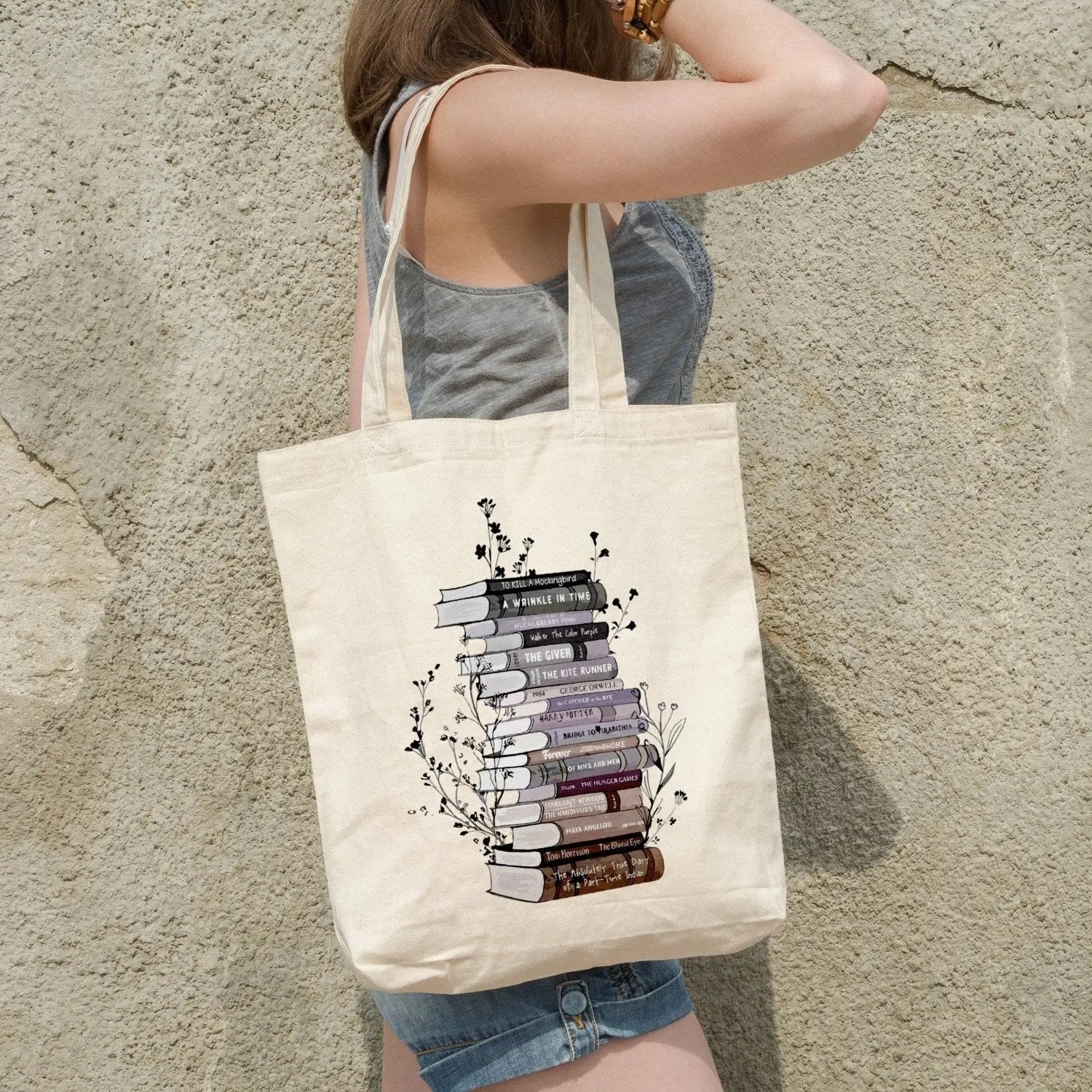 Cotton canvas tote bag with floral book stack design, perfect book lover gift.