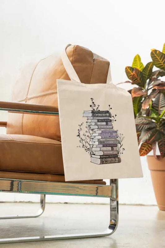 Cotton canvas tote bag with floral book stack design, perfect book lover gift.