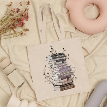 Cotton canvas tote bag with floral book stack design, perfect book lover gift.