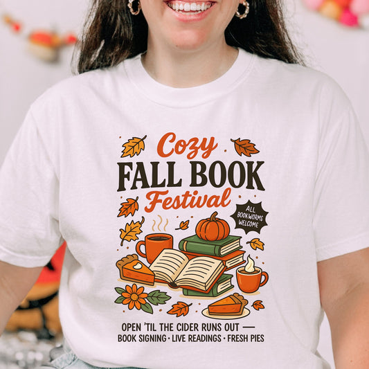 Cozy Fall Book Festival t-shirt with books, pumpkin pie, cider mugs, and autumn leaves in retro fall colors.