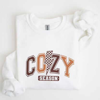 Cozy Season sweatshirt with retro varsity letters in fall colors and a checkered lightning bolt—perfect autumn apparel for cozy vibes.