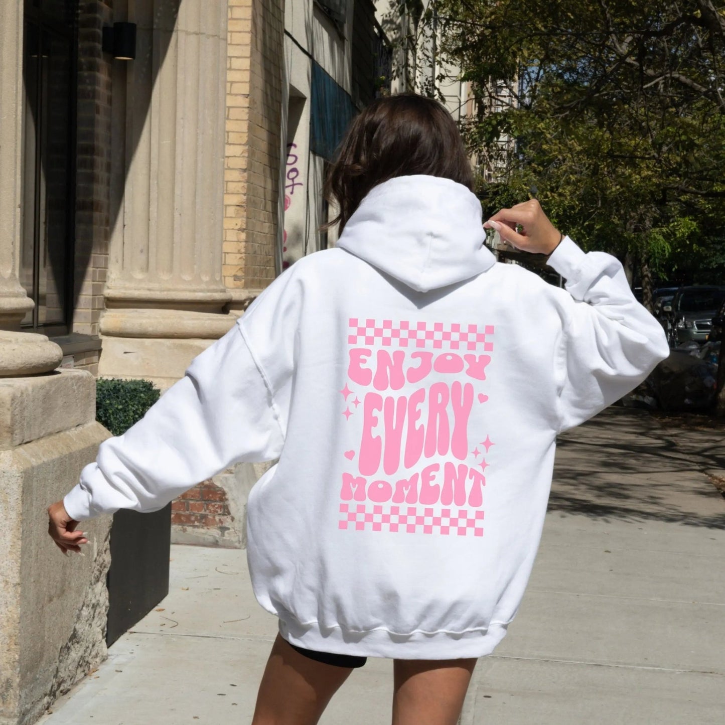 Enjoy Every Moment hoodie with retro checkerboard design, perfect for positive fashion and groovy vibes.