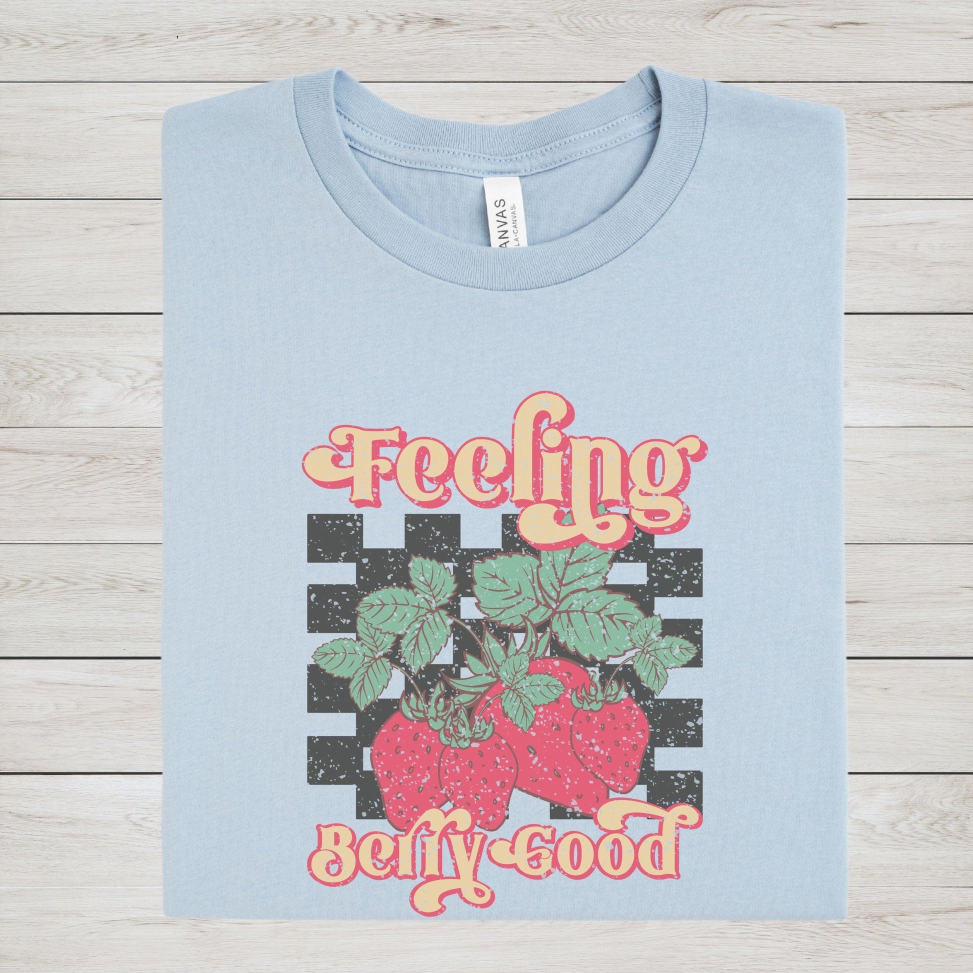 Vintage strawberry graphic t-shirt with retro font and checkerboard background, perfect for summer outfits and fruit lovers
