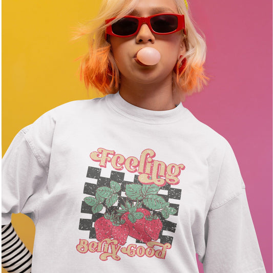 Vintage strawberry graphic t-shirt with retro font and checkerboard background, perfect for summer outfits and fruit lovers