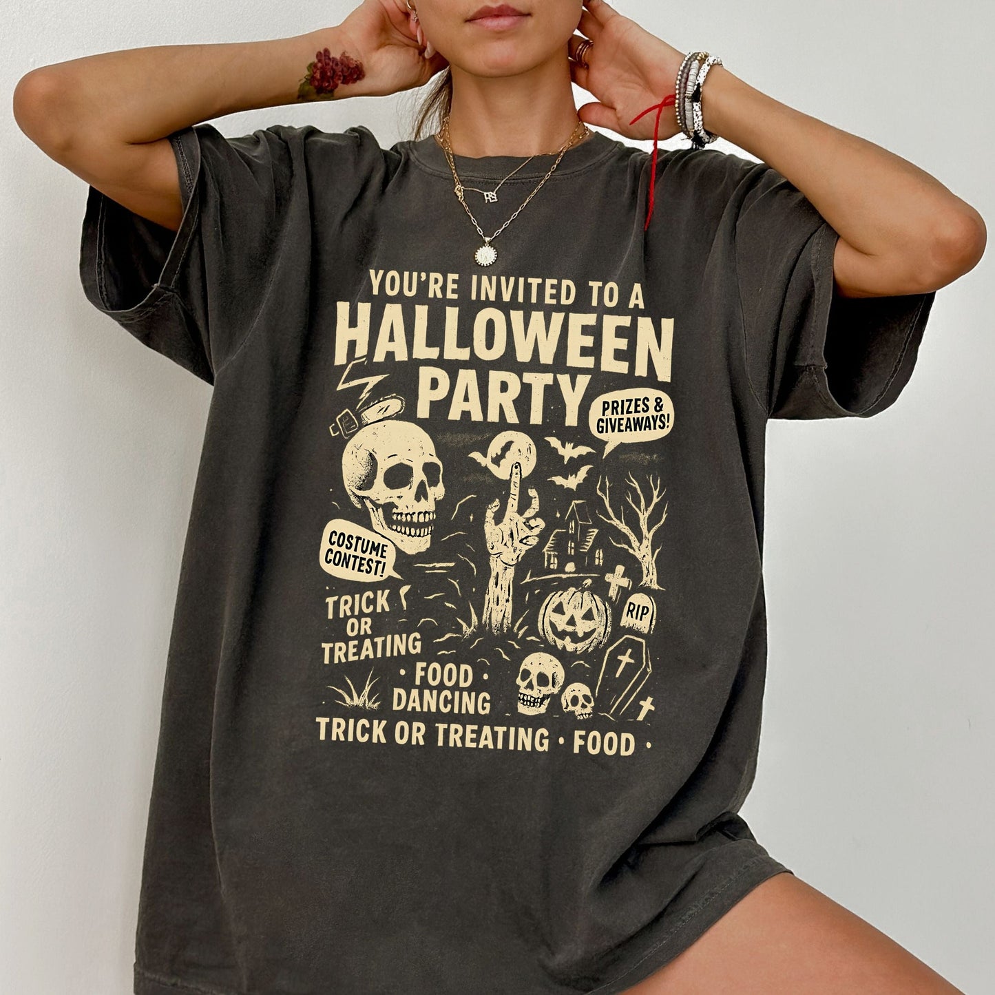 Retro Halloween party skeleton graphic tee with spooky cartoon skulls, tombstones, and vintage lettering