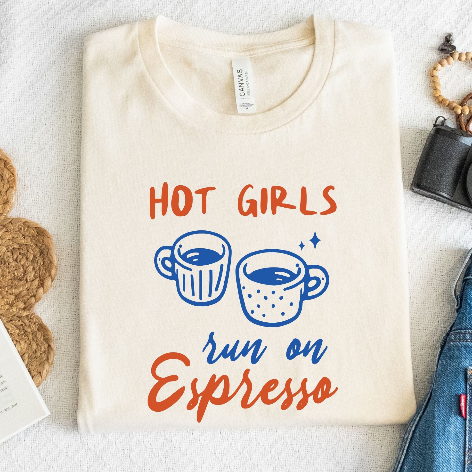 T-shirt with blue and orange graphic of espresso cups and bold text that says "Hot Girls Run on Espresso."